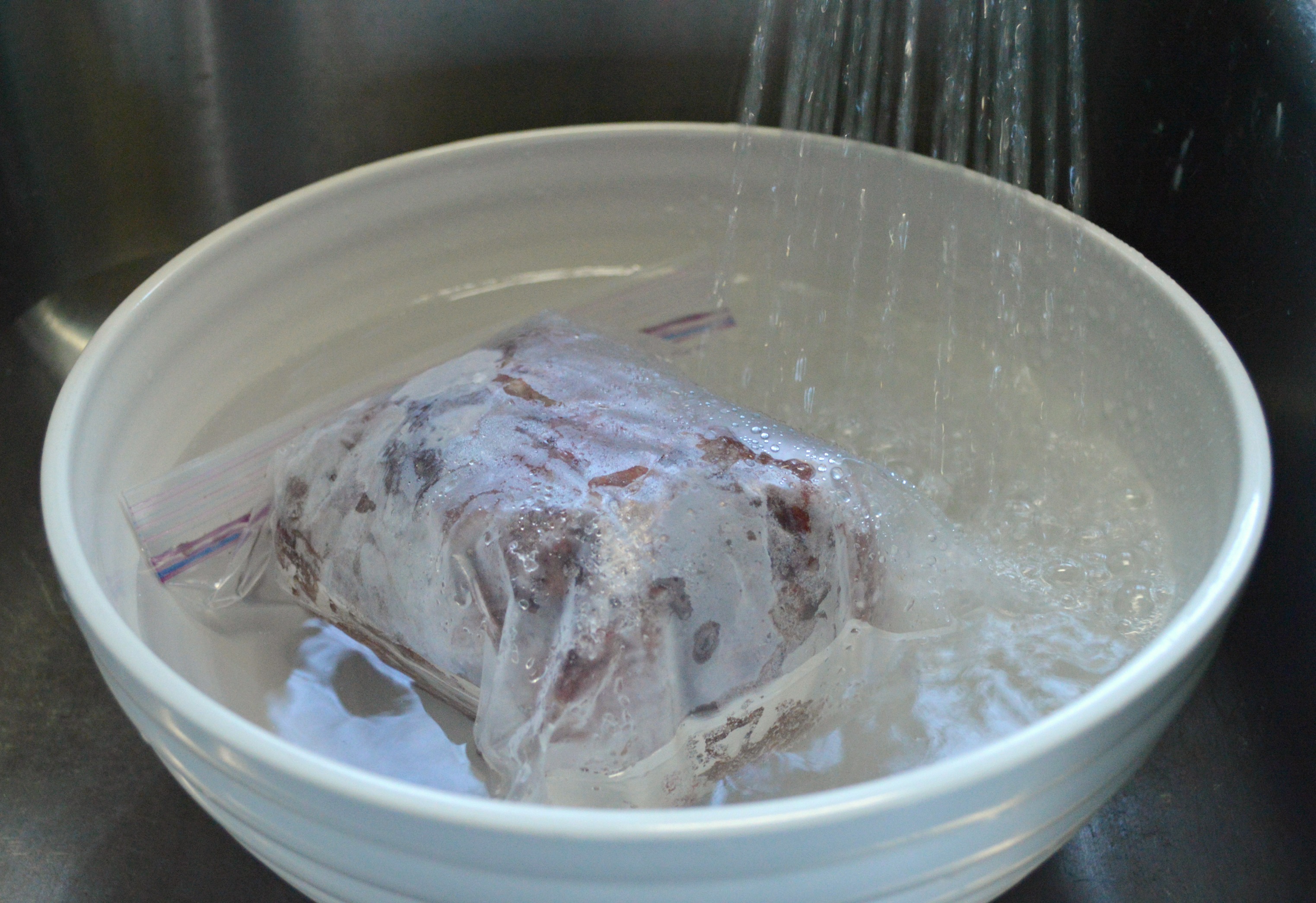 Thawing frozen meat in water