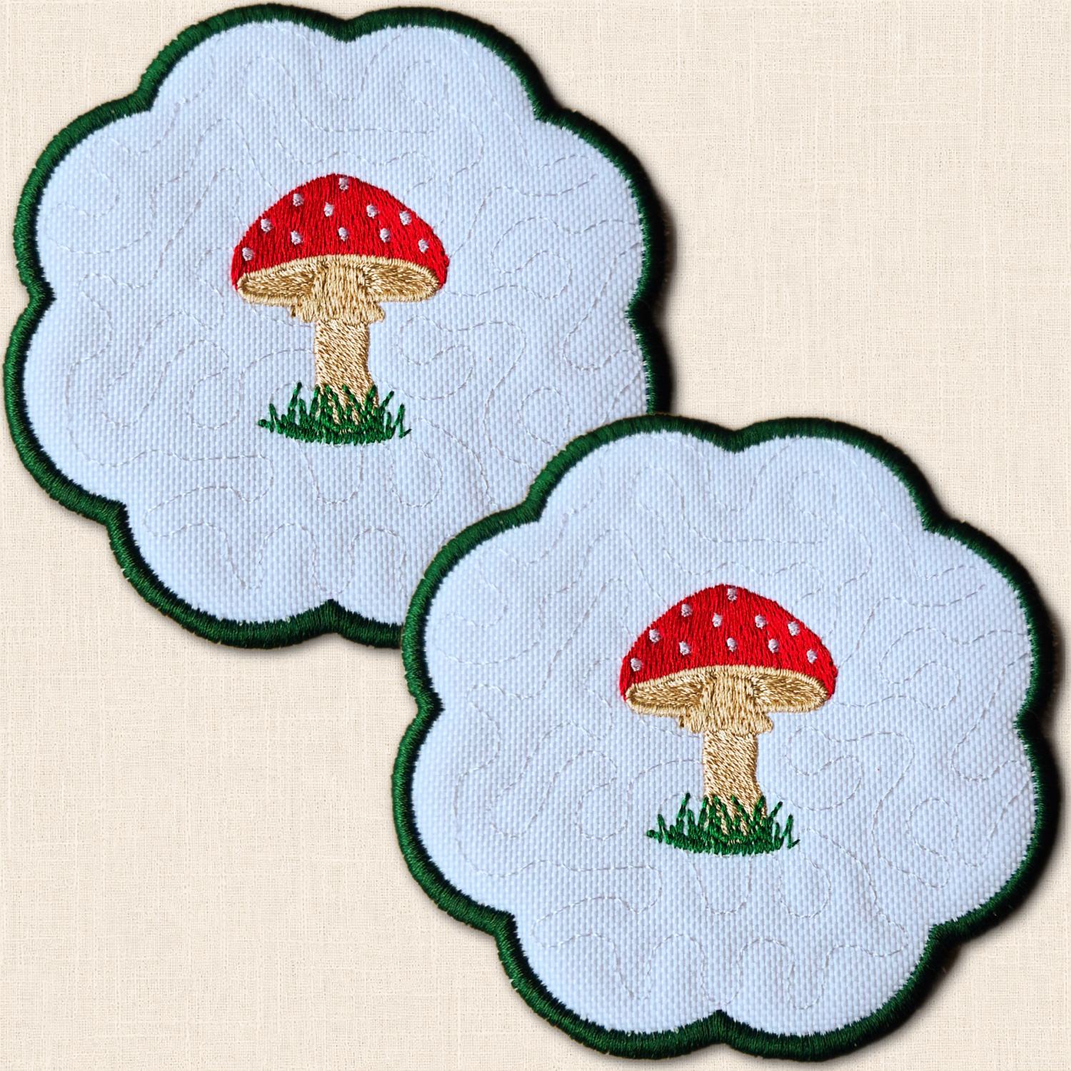 Set of two embroidered Toadstool Candle Coasters with red spotted mushrooms and scalloped green edging