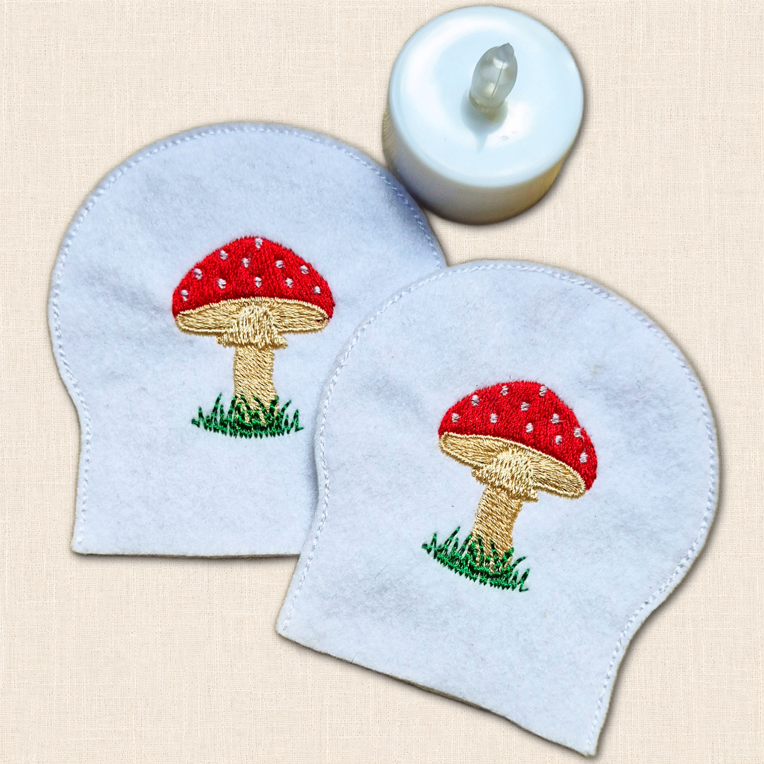 Toadstool Tealight Covers shown beside a standard LED tealight to demonstrate how the felt covers are used