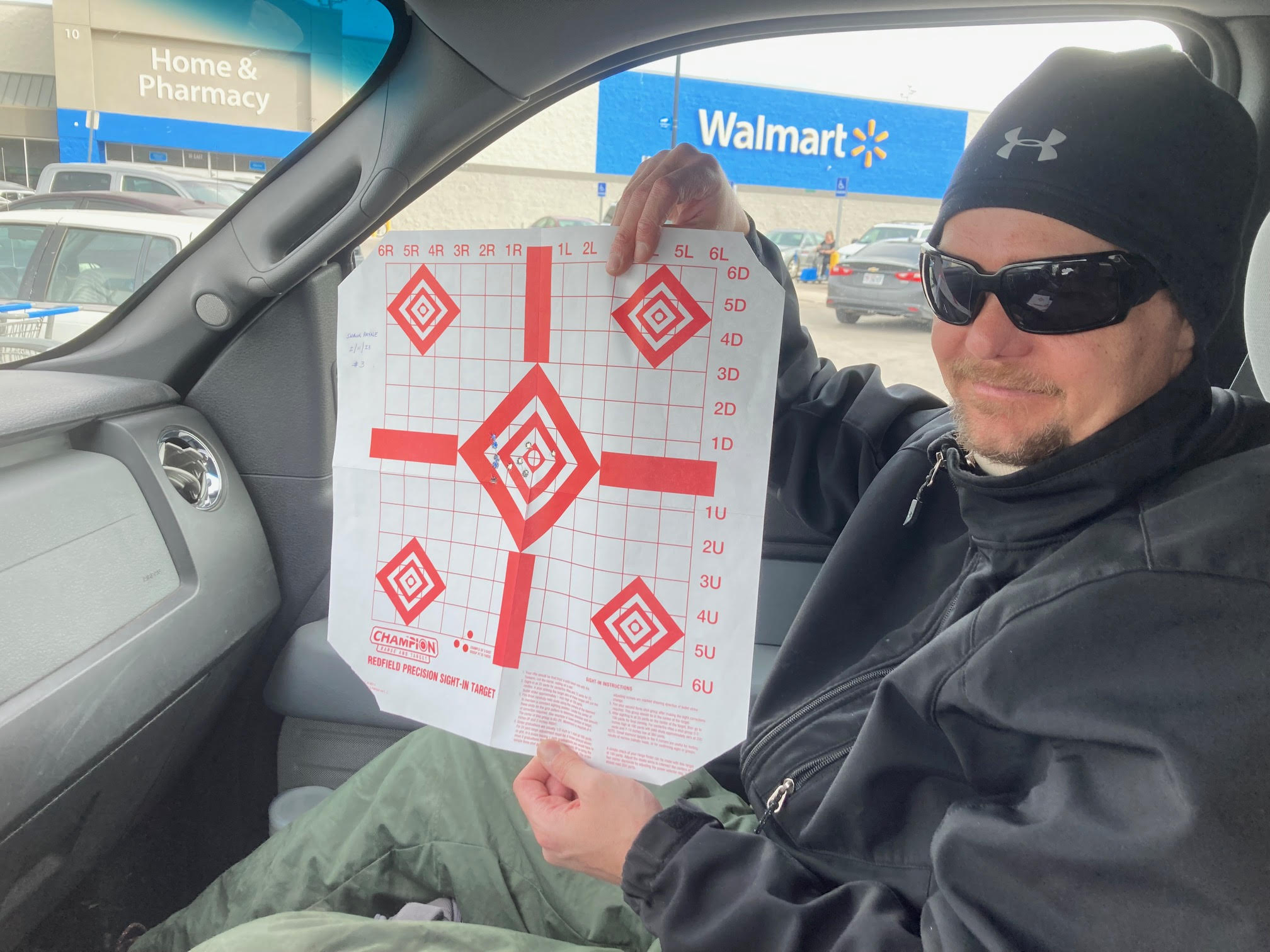 Blind veteran holding target showing how well he did shooting with the help of Digital Crosshairs DC1000SA adaptive scope clip-on