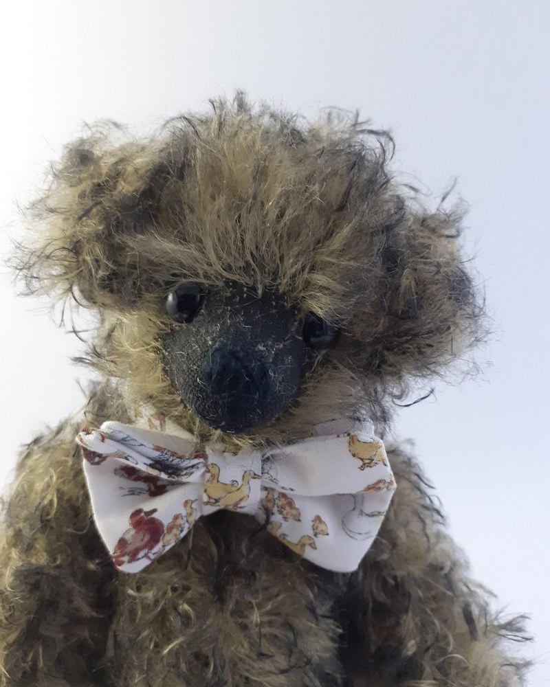 Handmade dark mohair Archie Bear wearing a patterned bow tie