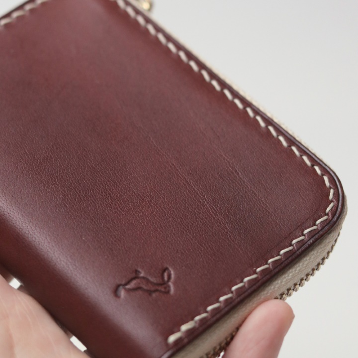 Grain on a brown Remi zipper wallet