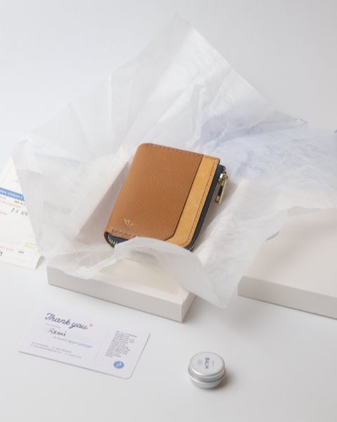 Brown Remi zipper wallet being packaged