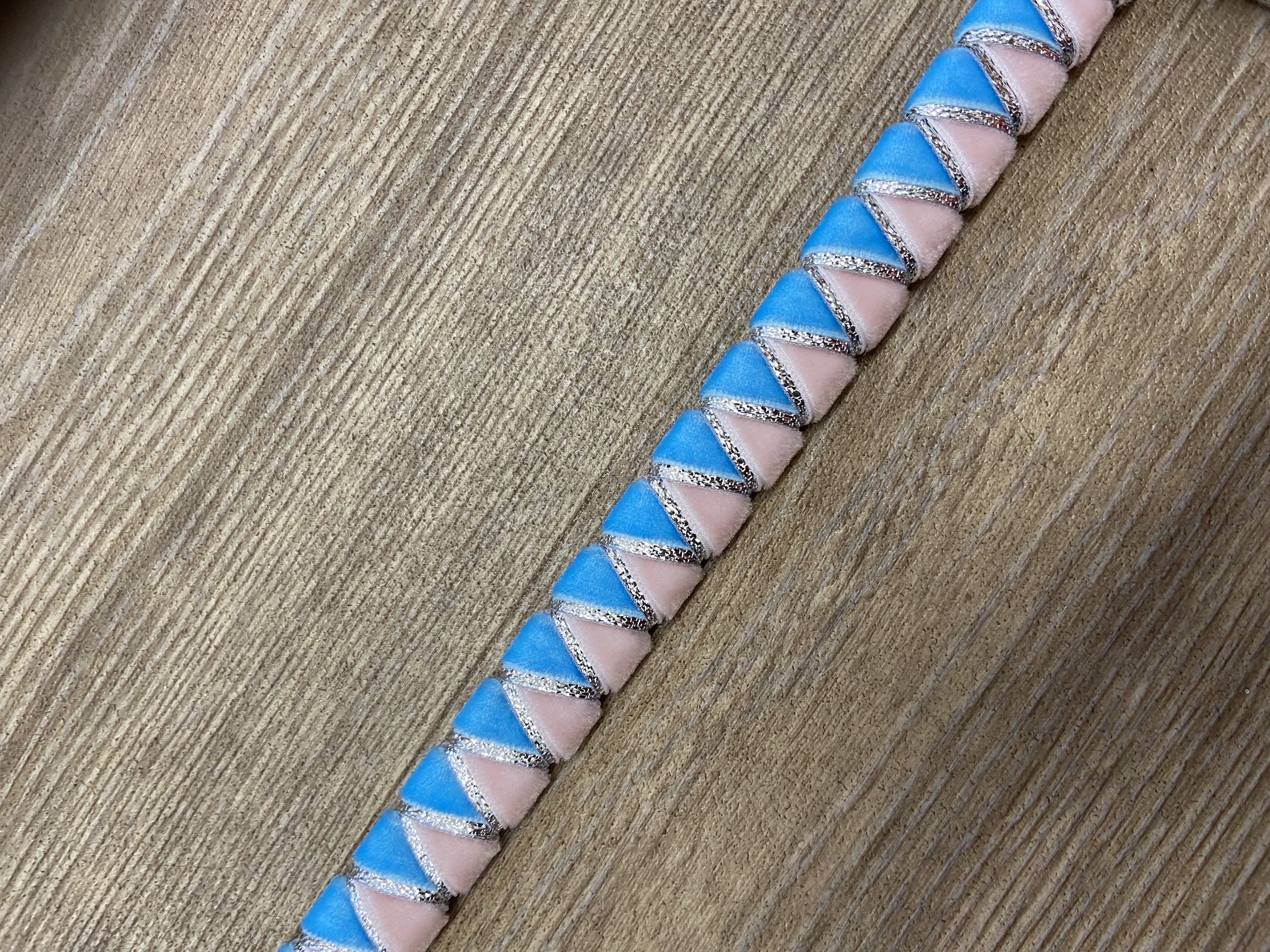 Sky blue and pale pink browband with silver underlay. Pony size. .Black leather.