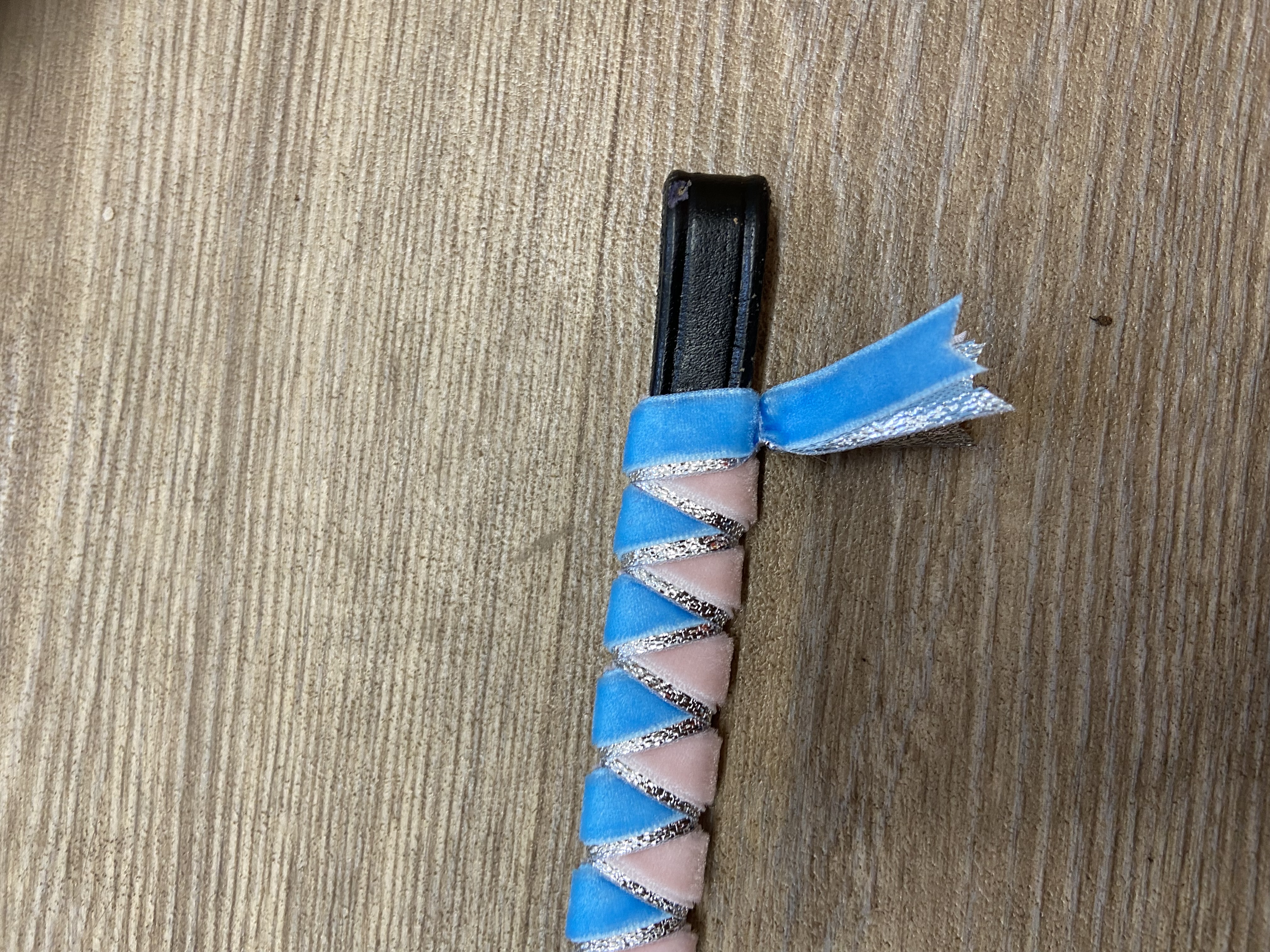 Sky blue and pale pink browband with silver underlay. Pony size. .Black leather.