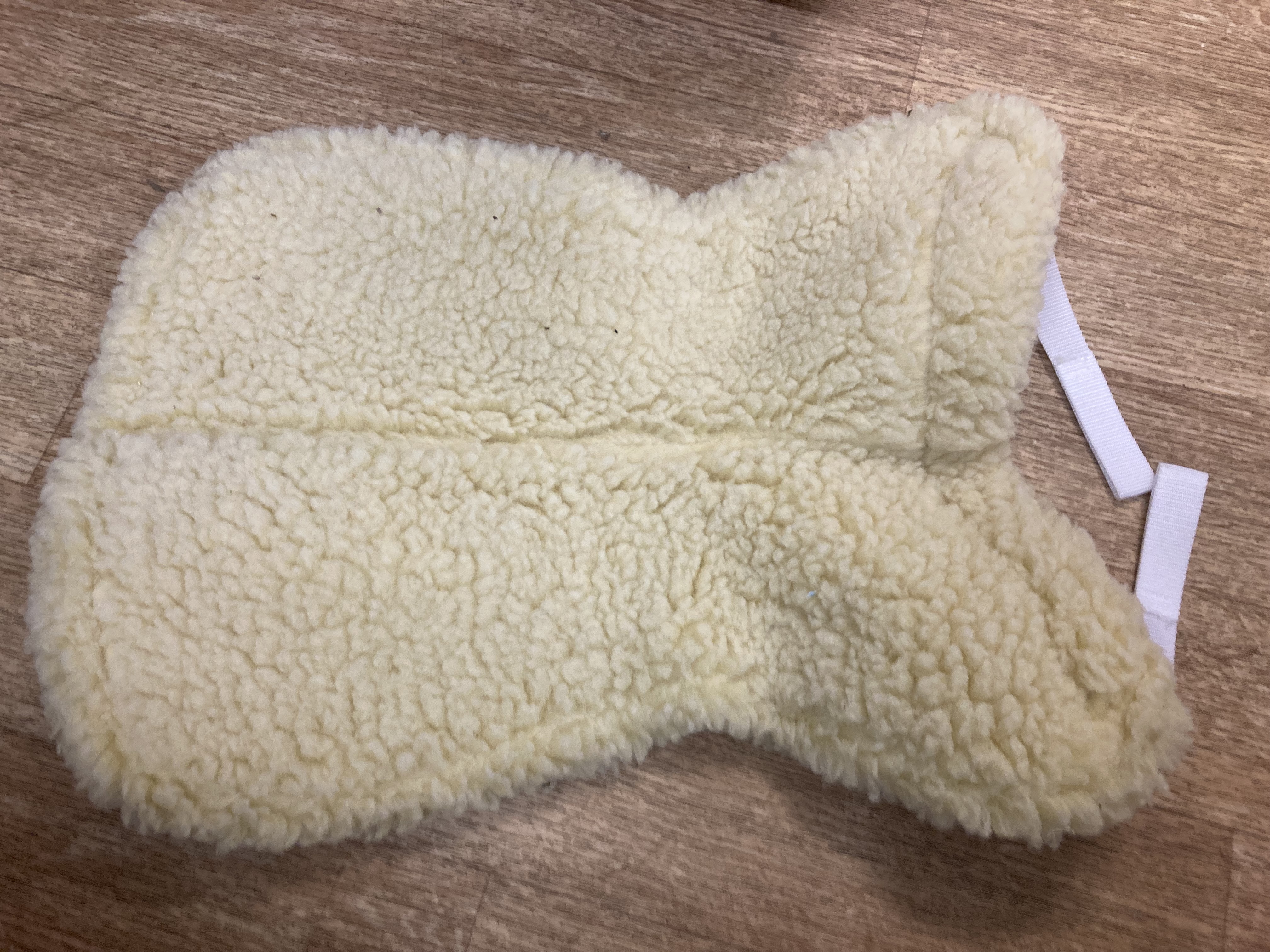 White faux sheepskin half pad. Shop soiled. 20.5” along spine