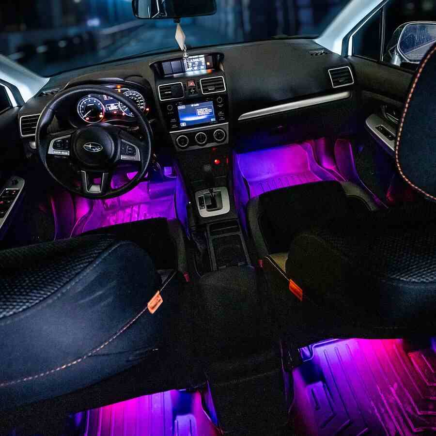 A car's interior footwell glowing with vibrant custom colors from the installed Alpena FloGlo LED strips.