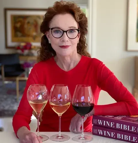 A set of Karen MacNeil Flavor First Crisp & Fresh glasses on a table with a bottle of white wine and a cheese board.