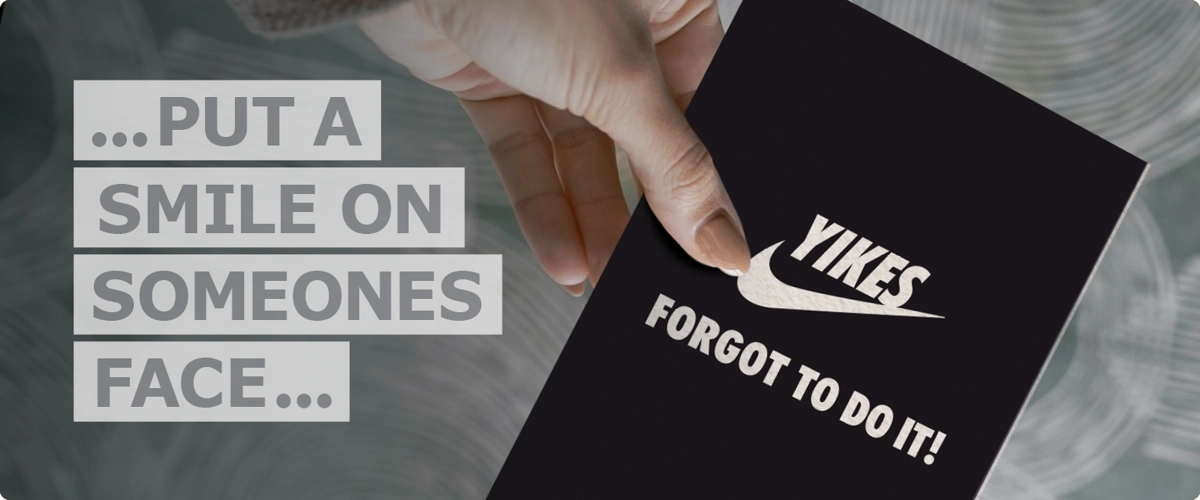 Hand holding Yikes design belated card next to text that reads ‘put a smile on someones face’.