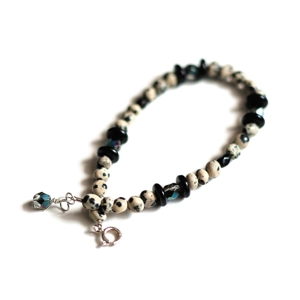 This bracelet features a boho laid-back design enhanced by a hint of sparkle. It is made with small dalmatian jasper (or dalmation stone) pebble beads that provide an organic look. The pebble beads showcase a creamy off-white base decorated with black spots, evoking the appearance of a dalmatian dog. I've also incorporated black Czech glass beads along with fire-polished black and brown beads. The difference between the stone and glass beads produces a interesting appearance. I have completed the look with a sterling silver spring ring clasp and a wire-wrapped dangle crafted from a fire-polished black and brown bead.

MEASUREMENTS: Total length is 8 1/4