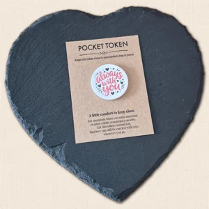 Always With You pocket token with red wording and black heart details on a kraft backing card, displayed on a slate heart photography prop.