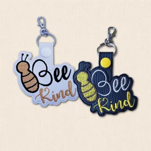 Black and white Bee Kind faux leather keyrings with embroidered bee design and positive wording