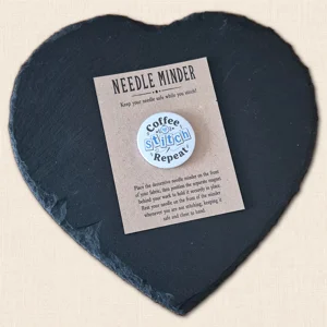 Coffee Stitch Repeat needle minder on kraft presentation card on a black heart-shaped slate