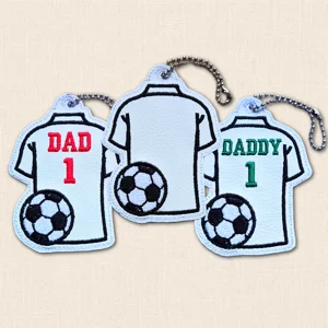 Three embroidered football shirt bag charms in blank, Dad 1 and Daddy 1 designs with football detail and silver ball chains.