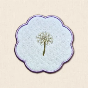 Dandelion Candle Coaster with embroidered seed head, pale stitched background and purple scalloped border.
