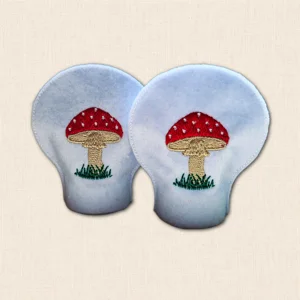 Pair of embroidered Toadstool Tealight Covers made from white felt with red spotted mushrooms and grassy details