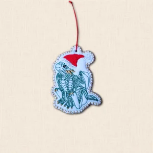 Baby dragon Christmas ornament embroidered on white felt with green dragon detail, red Santa hat and red hanging cord