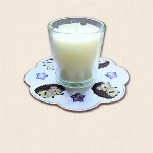 Hedgehog Candle Mat with glass candle jar, embroidered hedgehogs, purple flowers and softly scalloped edging
