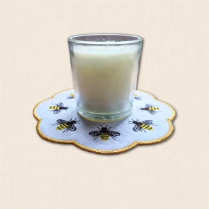 Honey Bee Candle Mat with glass candle jar, embroidered bees, subtle honeycomb stitching and golden scalloped edging