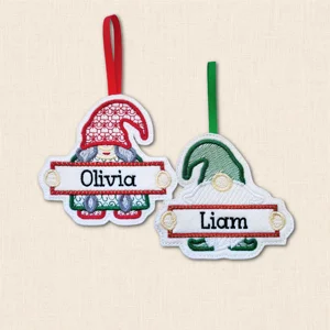 Personalised male and female Christmas gnome decorations embroidered on white felt with the names ‘Olivia’ and ‘Liam’ on stitched banners