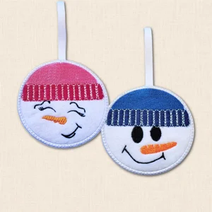 Snow Boy and Snow Girl Christmas decorations embroidered on white felt with blue and pink winter hats and white hanging ribbons