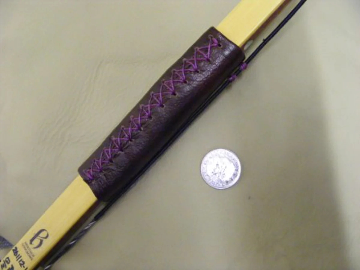 A bamboo-backed target bow with a stitched leather grip