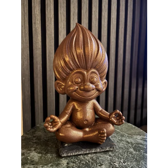 Retro penntroll i skimrande rostfärg med stort hår och glatt leende, sittande i yogaposition. Dekorativt lyckotroll från Ting & Tankar.