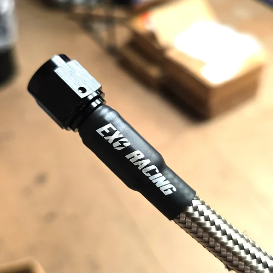 Exoracing heat shrink tag fitted to AN hose sleeve