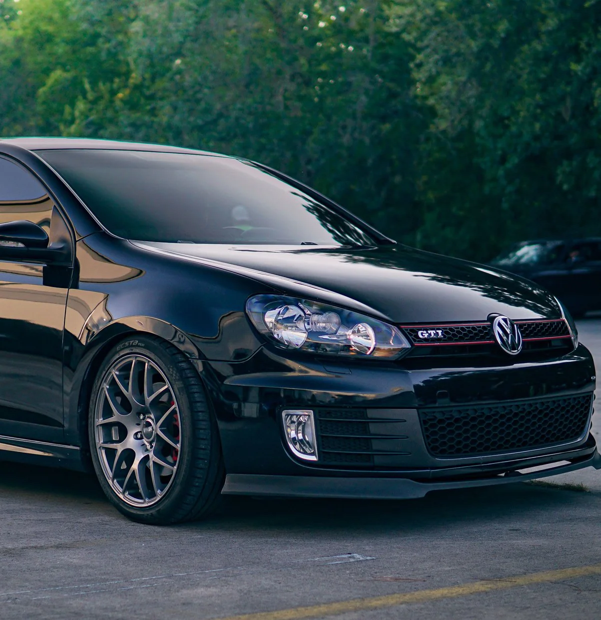 A lowered Volkswagen Golf GTI on aftermarket alloy wheels with a front splitter