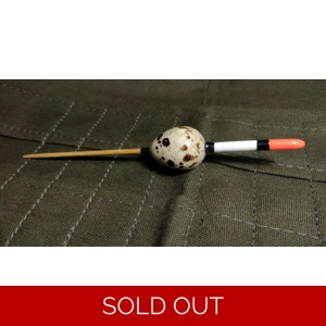 A unique river fishing float, Avon style, made from a real quails egg on a cane stem with a goose will sight tip to make it more visible at range when long trotting down stream for big roach or grayling. It is displayed on a green canvas float roll for effect .