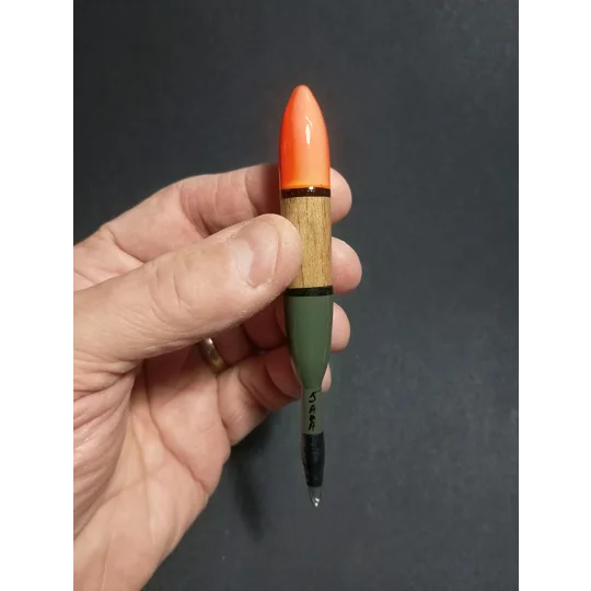5AAA balsa chubber float being held for scale