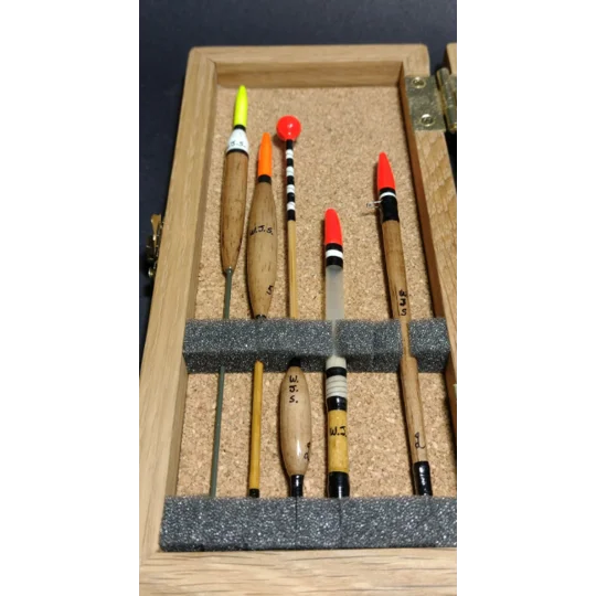 Traditional fishing floats protected in foam-lined oak float case