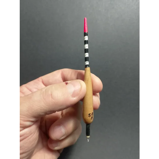 handmade carp margin dart fishing float held in hand to illustrate the size and scale of the float