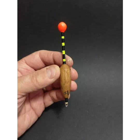 Handmade balsa-bodied Zander Bob fishing float with cork sight tip, held in hand to show size and scale