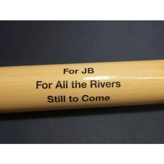 Close-up of personalised bamboo fishing float tube with custom printed message sealed beneath the lacquer