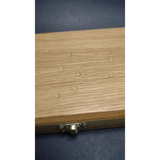 water beads on the repellent waxed surface of a wooden traditional fishing float box