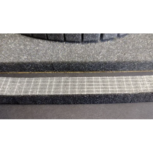 Close-up of sticky backing on foam float holder strip