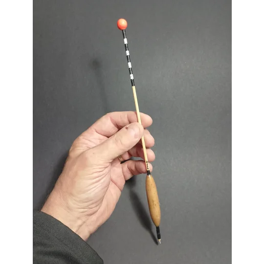 Traditional handmade 4SSG Windbeater float with long stem and sight tip, held in hand for scale