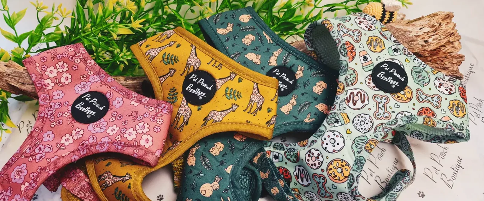 Patterned dog harnesses laid out on moss