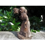 Folk art figurine of an old smiling country girl carrying a bundle of sticks armed with an axe ironware with great detail