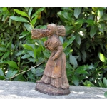 Folk art figurine of an old smiling country girl carrying a bundle of sticks armed with an axe ironware with great detail