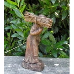 Folk art figurine of an old smiling country girl carrying a bundle of sticks armed with an axe ironware with great detail