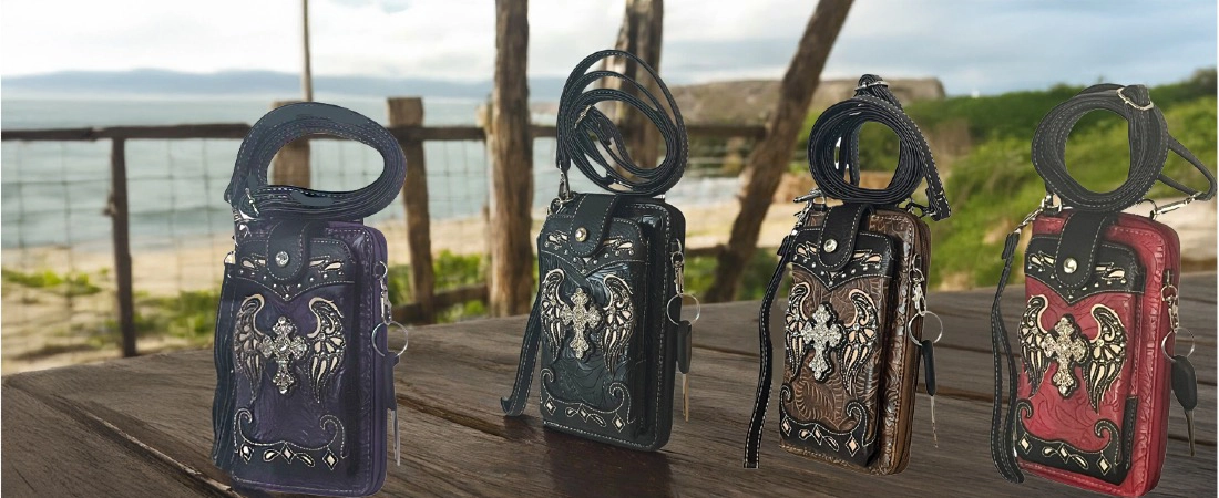 Cross purse phone wallets with embroidered wings on wooden platform