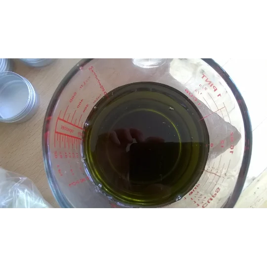 May include: A clear glass measuring jug with a red scale filled with a dark green liquid. The text "double chickweed infused organic sweet almond oil" is written in black on a white background.