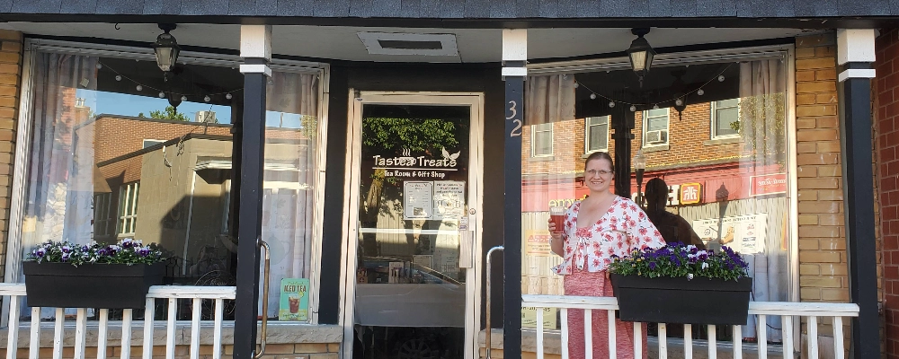 frount of tearoom with Jenny the owner of the tastea treats standing on the porch.