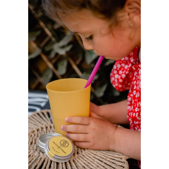 Eco-friendly reusable silicone straws with a lightweight case. Child drinking with straw