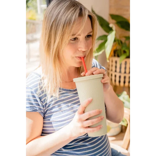 A female using a reusable silicone straw to drink
