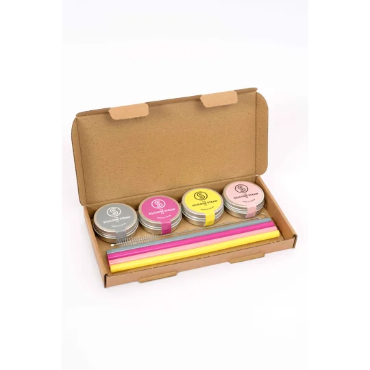 Image of inside the reusable straw gift set. It contains a range of reusable silicone straws in travel tins and a cleaning brush