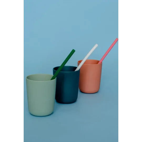 Three colourful silicone straws in three colourful cups