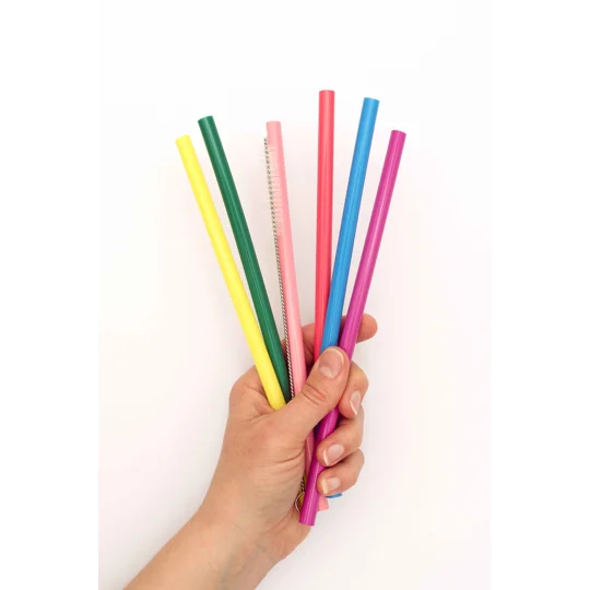 a range of colourful reusable silicone straws bunched up in a persons hand